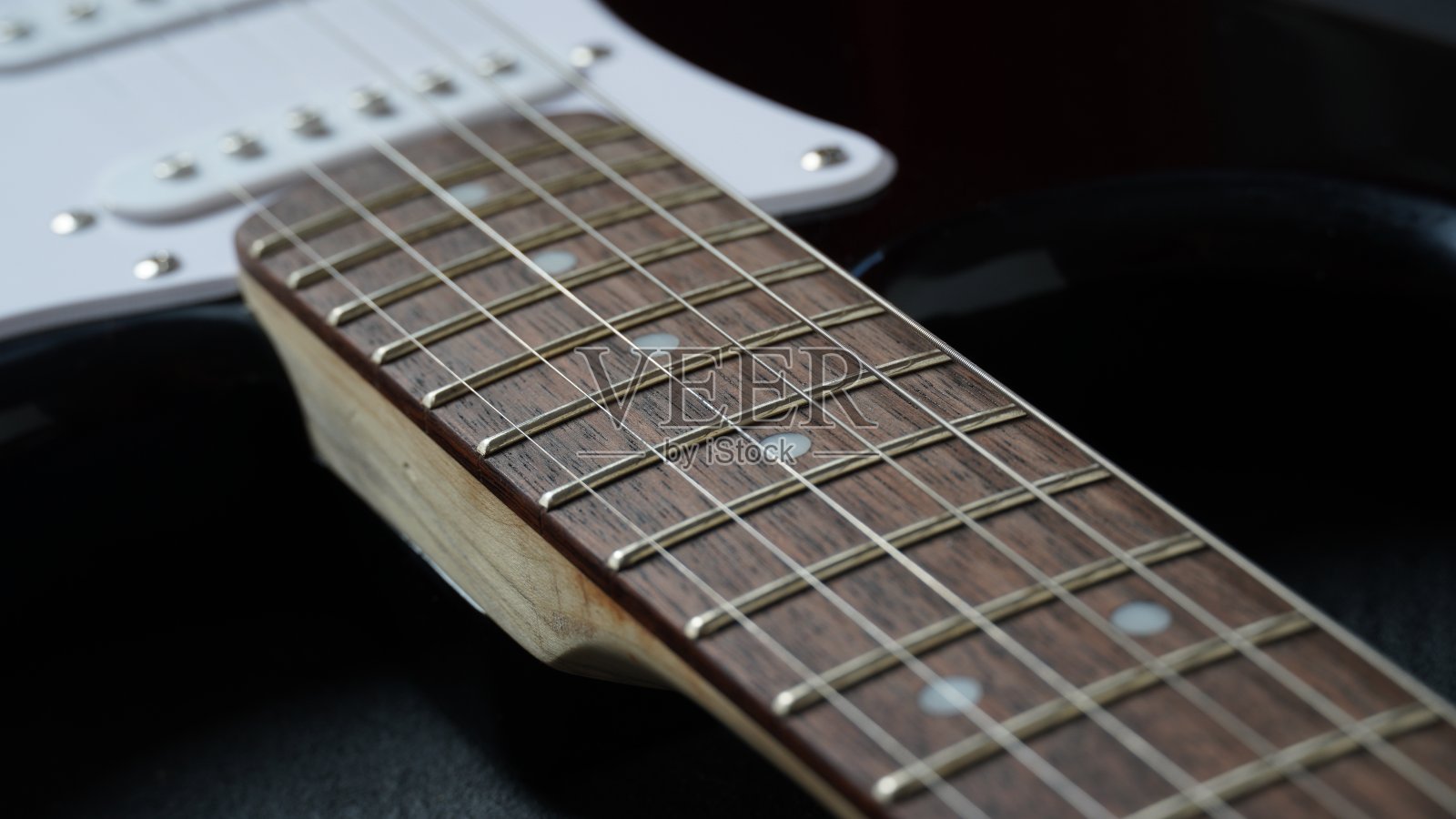 深色背景上的黑色电吉他琴颈照片摄影图片