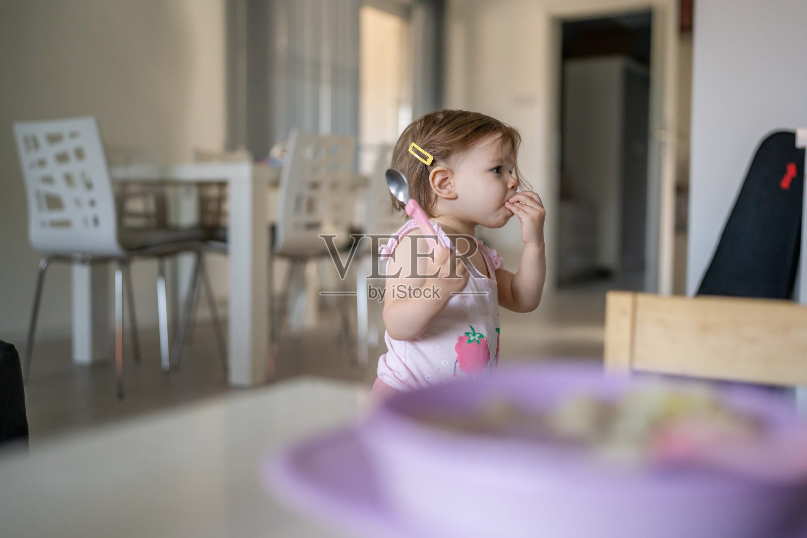 一个孩子,白人蹒跚学步的女婴,独自在家里的桌子上吃饭,在房间里,真人复制空间,早期儿童发展概念,学习,侧面观点,保持食物健康饮食照片摄影图片