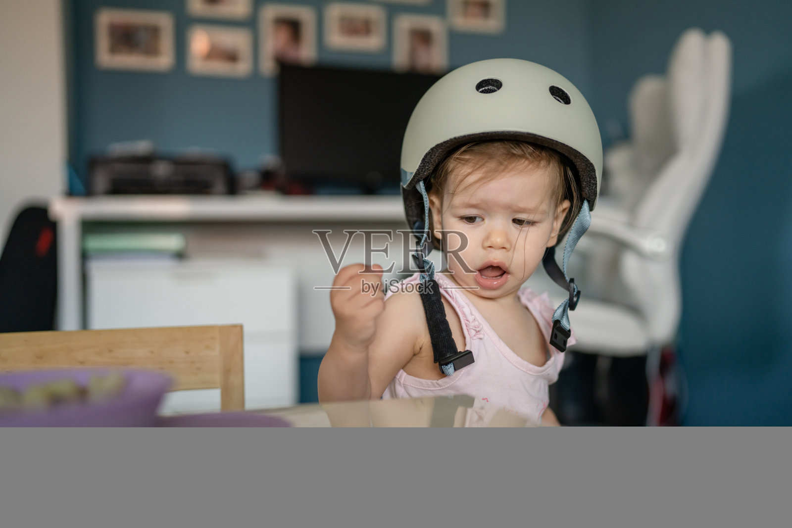 前视图肖像的一个女孩小白种人蹒跚学步的婴儿戴防护头盔在头上,而站或走路在家里的房间里成长学习新技能早期发展的概念照片摄影图片