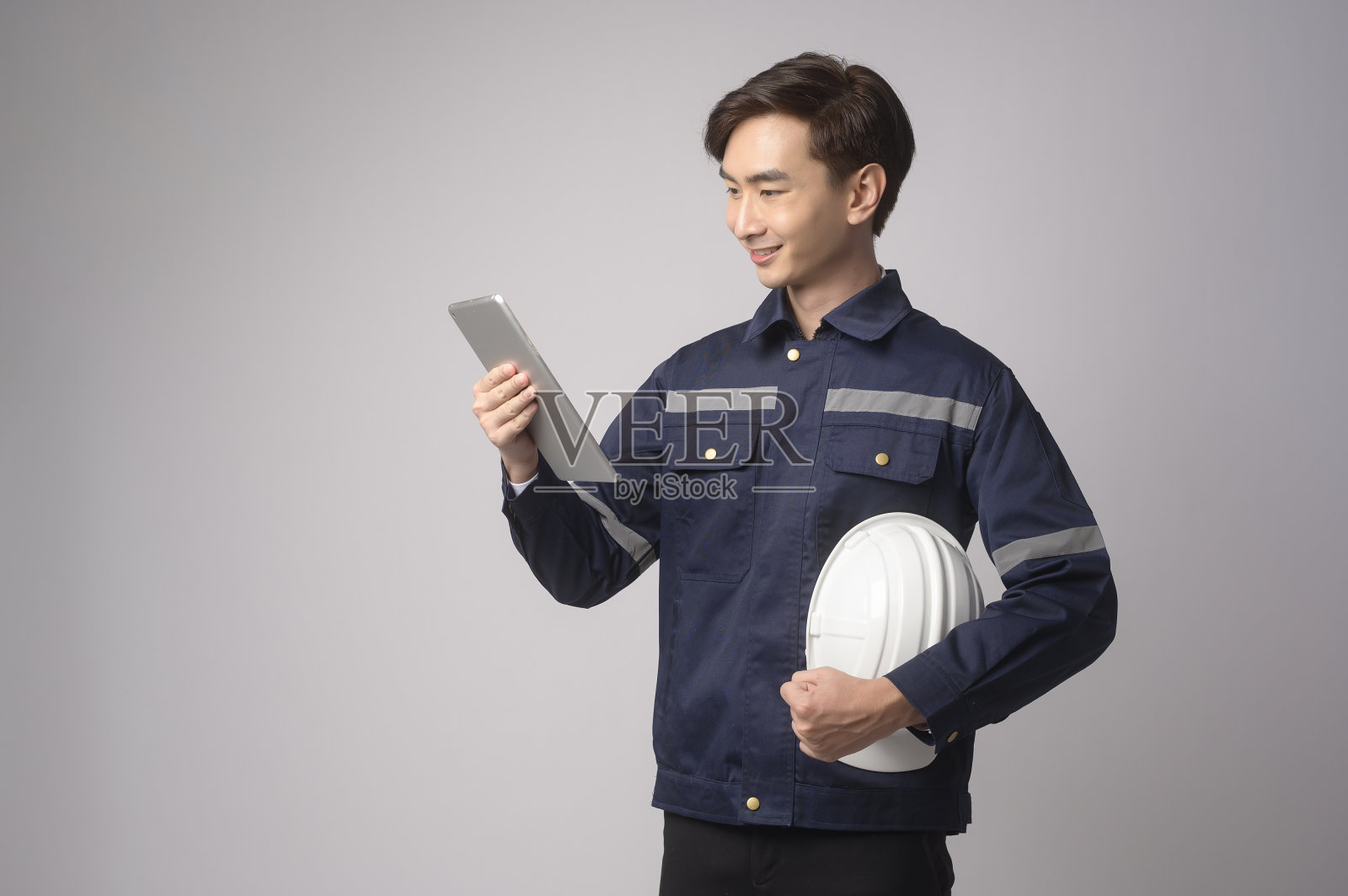 肖像的男性工程师戴着防护头盔在白色背景工作室。照片摄影图片