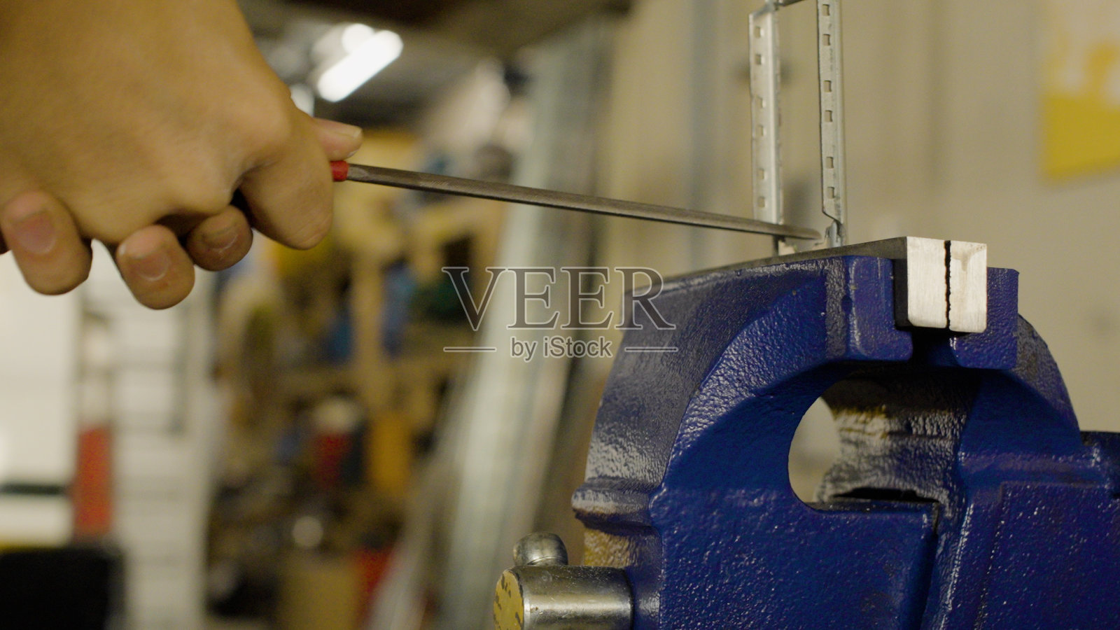 那个人正在用工具切割电气材料。照片摄影图片