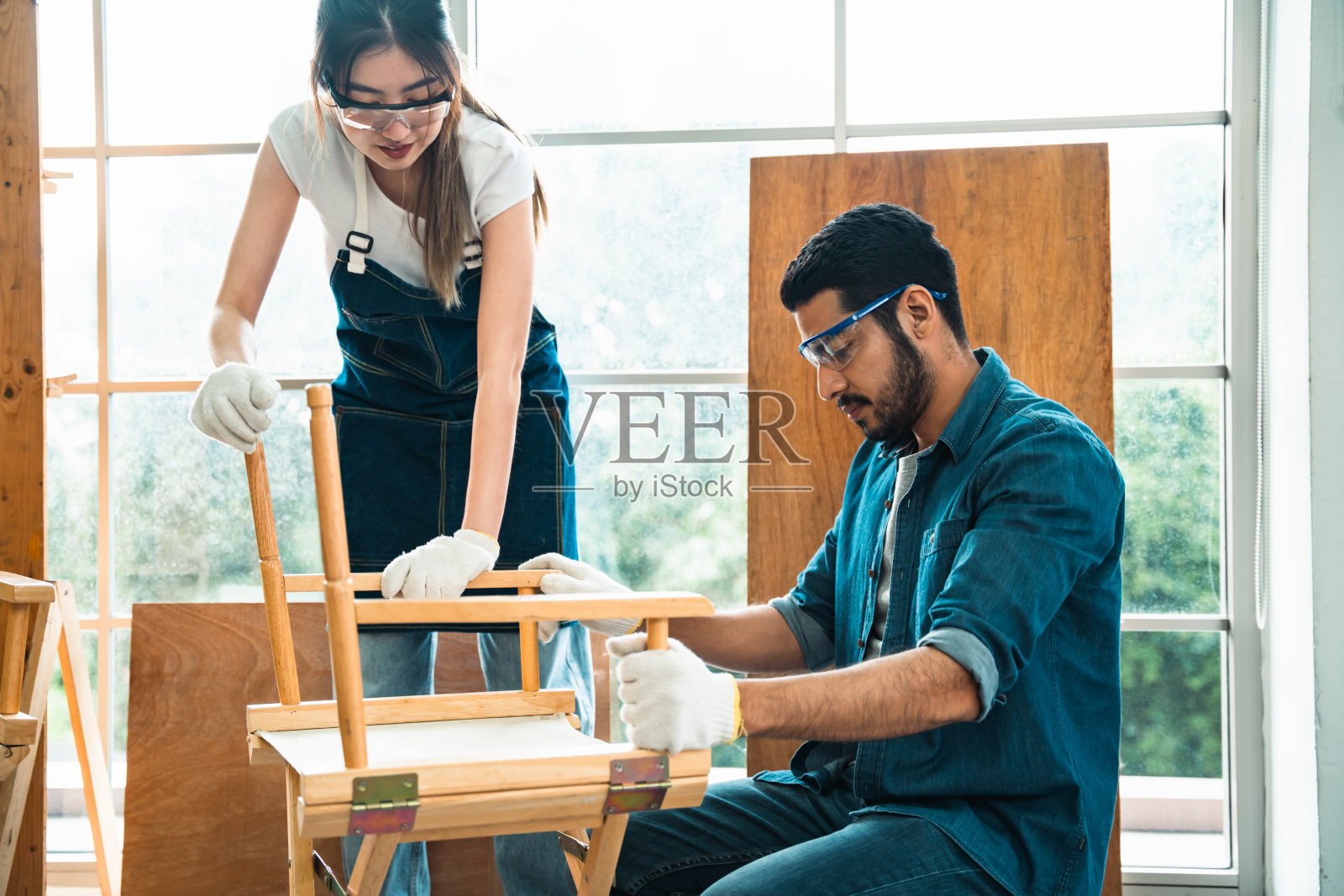 在木材场组装椅子和测试椅子强度的木匠。照片摄影图片