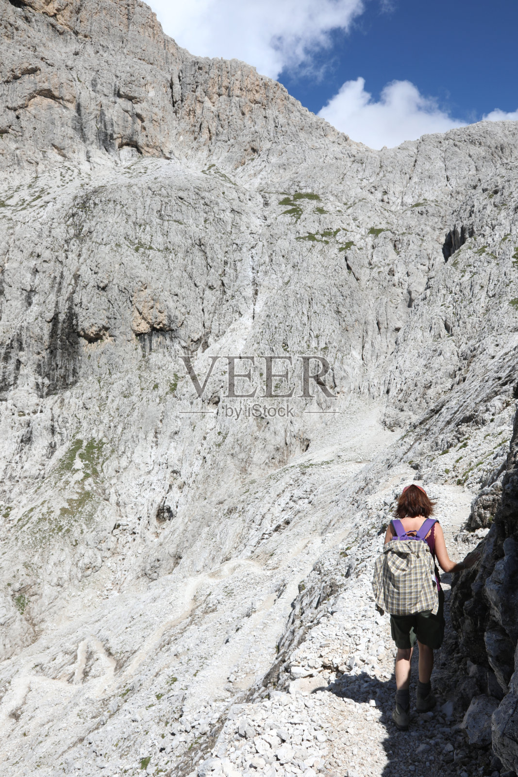 一名年轻女子走在被称为意大利帕莱集团的欧洲阿尔卑斯山的白云石小径上照片摄影图片