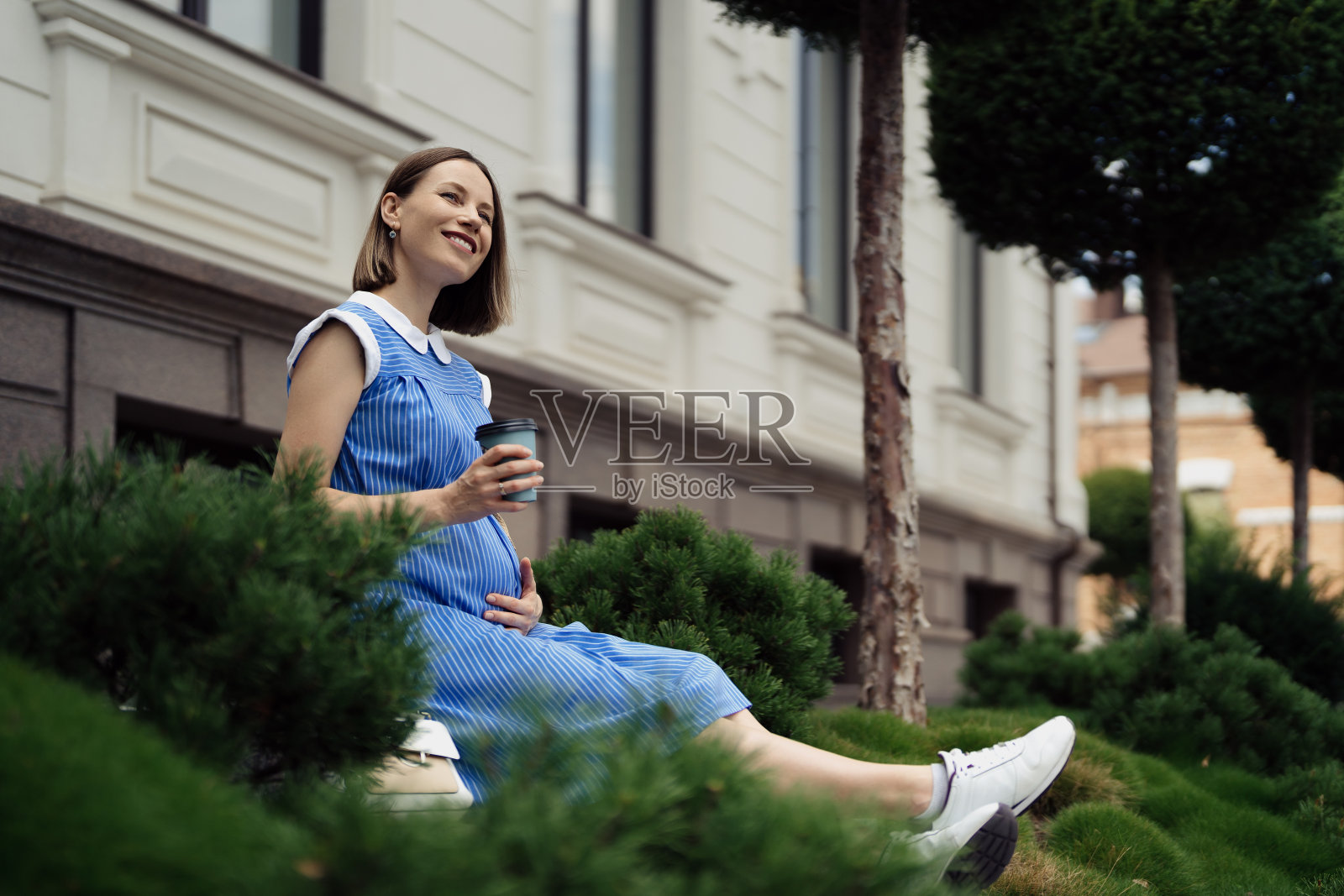 孕妇坐着休息时摸肚子照片摄影图片