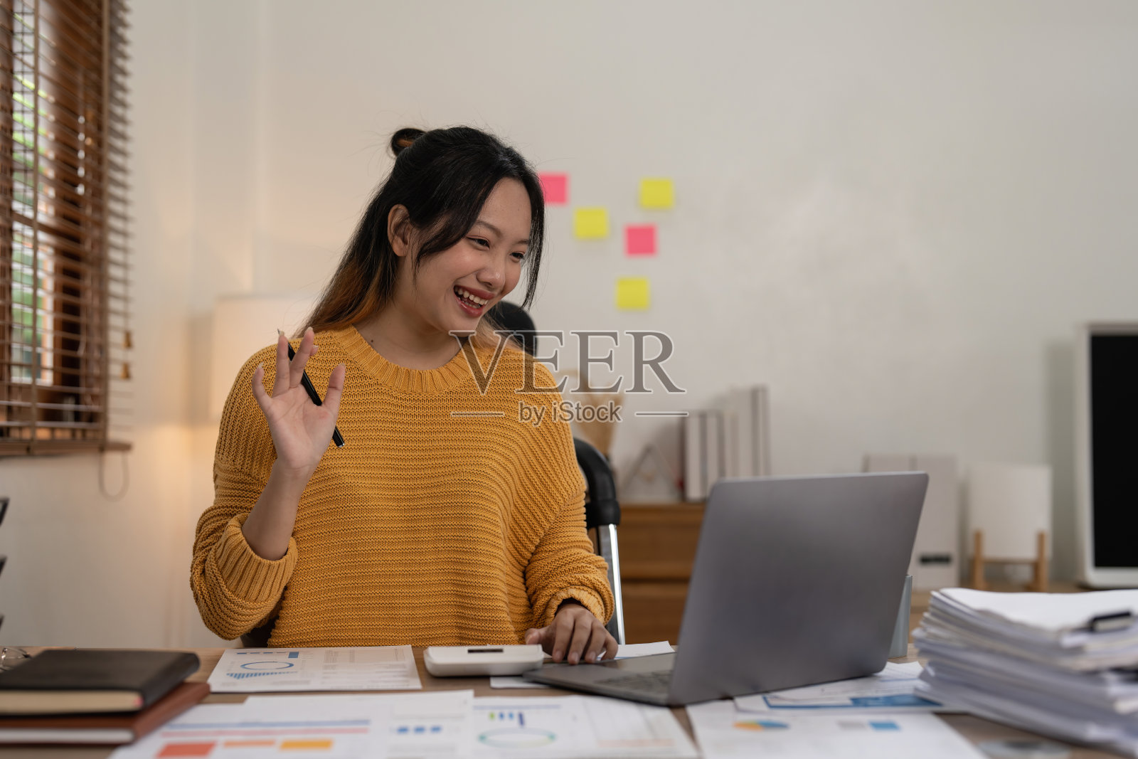 亚洲会计通过笔记本电脑与客户进行视频通话。在家办公的概念照片摄影图片