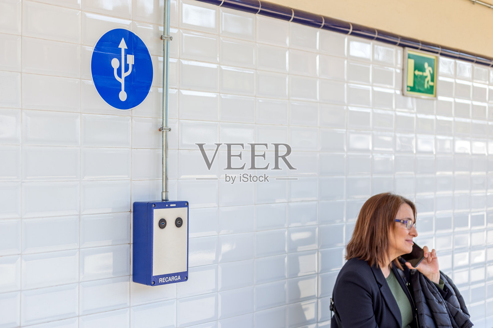 一名女子在地铁站的公共USB充电桩旁打电话照片摄影图片