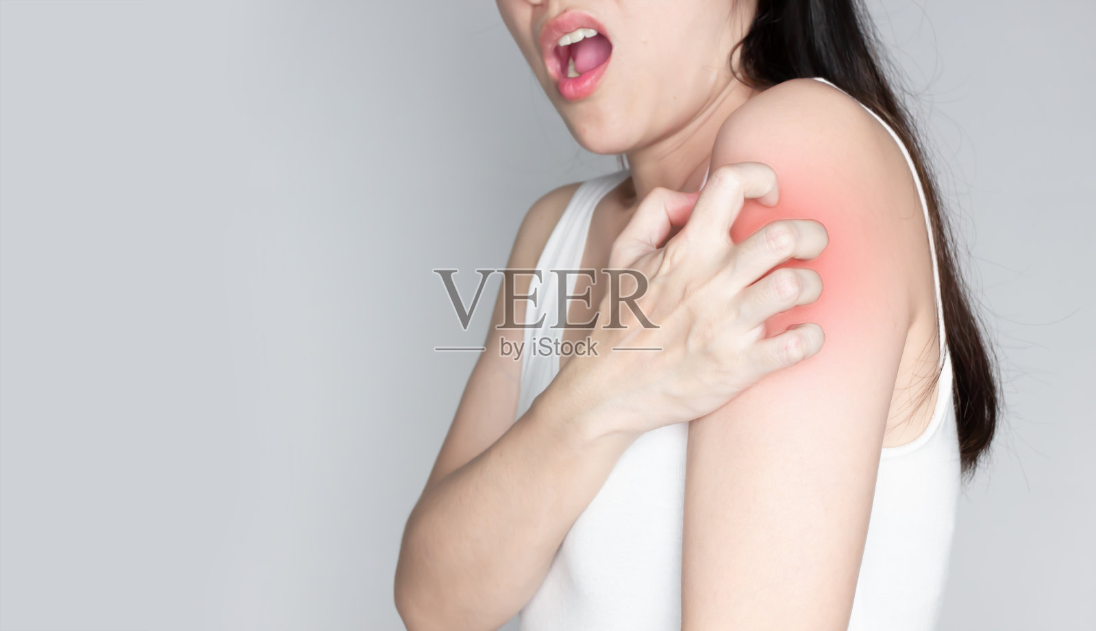 亚洲妇女搔肩膀又痒。皮肤问题疥疮照片摄影图片