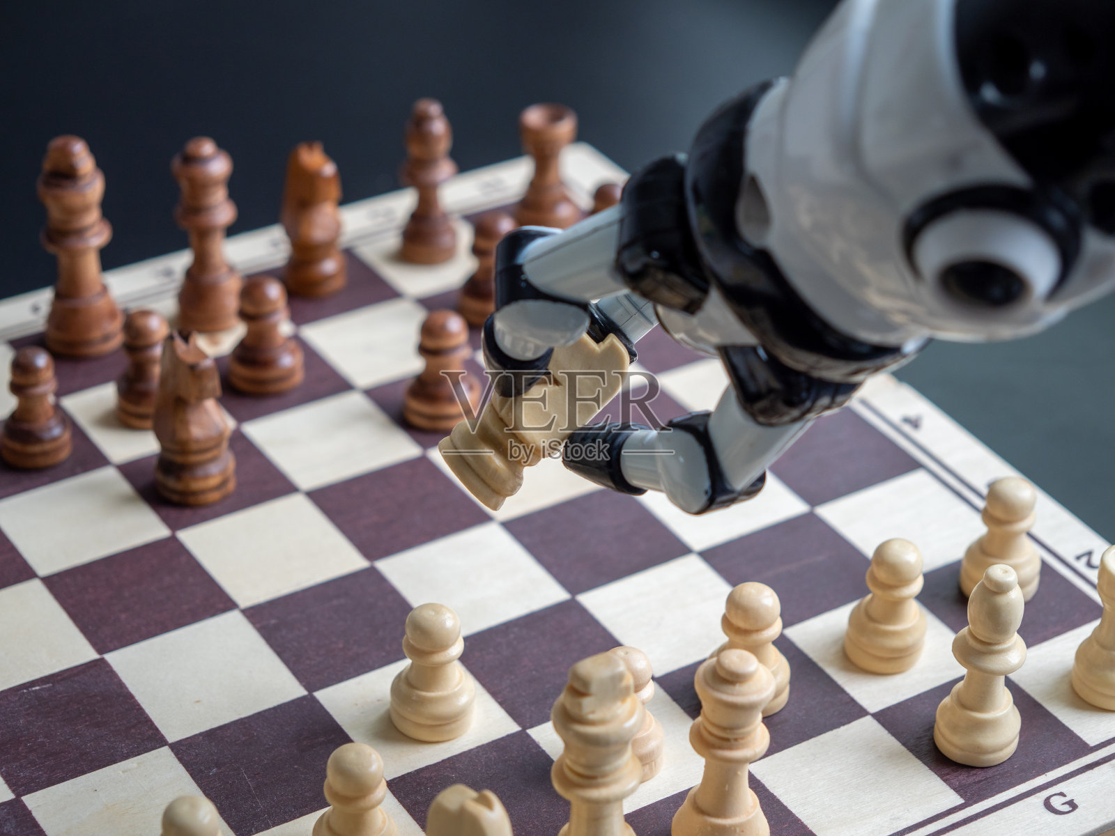 一个人在和机器人下棋。照片摄影图片