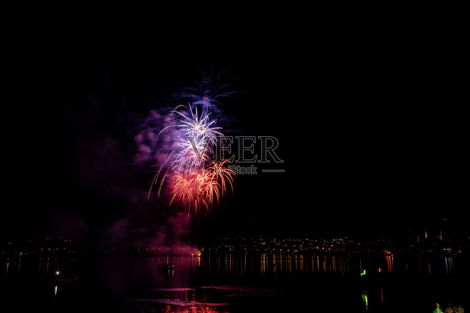 夜晚苏黎世湖上空美丽明亮的烟花爆炸照片摄影图片