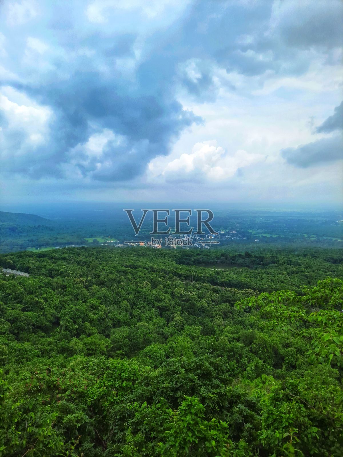 垂直拍摄的广阔森林与农村定居点从远处看和上面多云的天空照片摄影图片