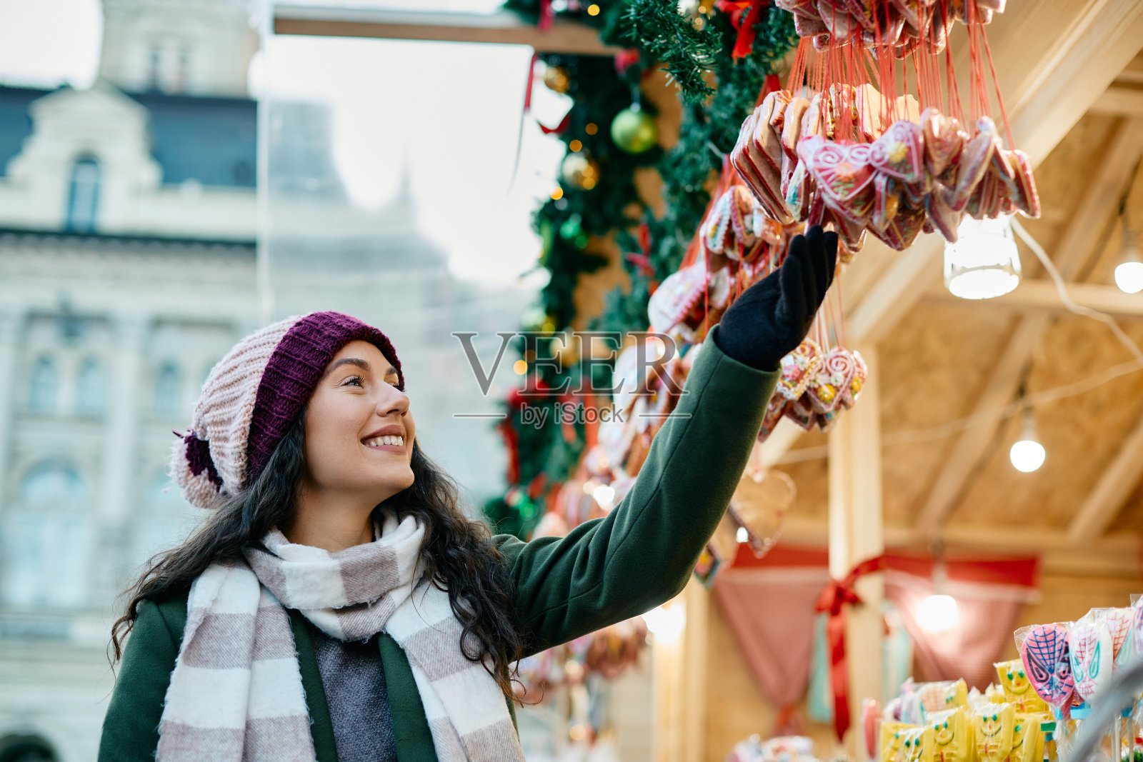 寒假期间,快乐的女人在圣诞市场上挑选糖果。照片摄影图片