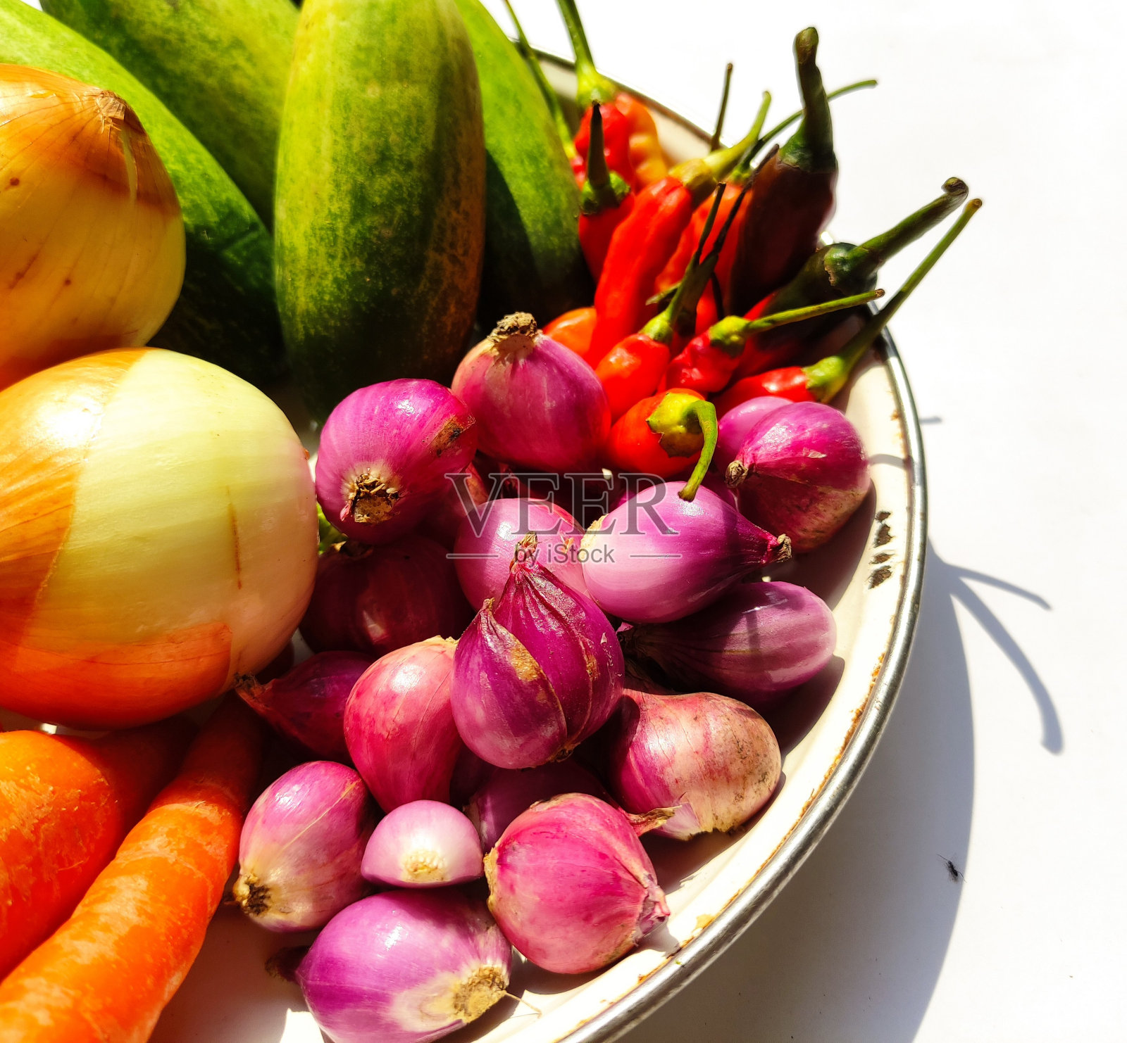 传统市场上的新鲜黄瓜、青葱、辣椒、胡萝卜和洋葱。照片摄影图片