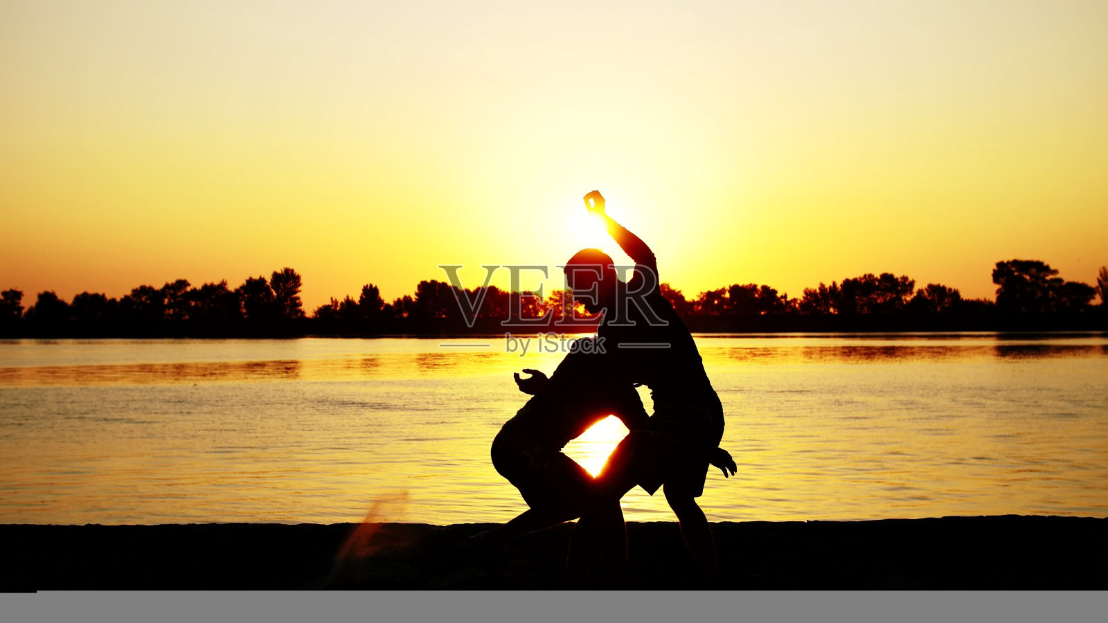 两个黝黑的男子,迎着日出,迎着光明,拳打脚踢,在陪练中搏击,训练着一对打击技术。在沙滩上,在货港,在水边,在夏天照片摄影图片