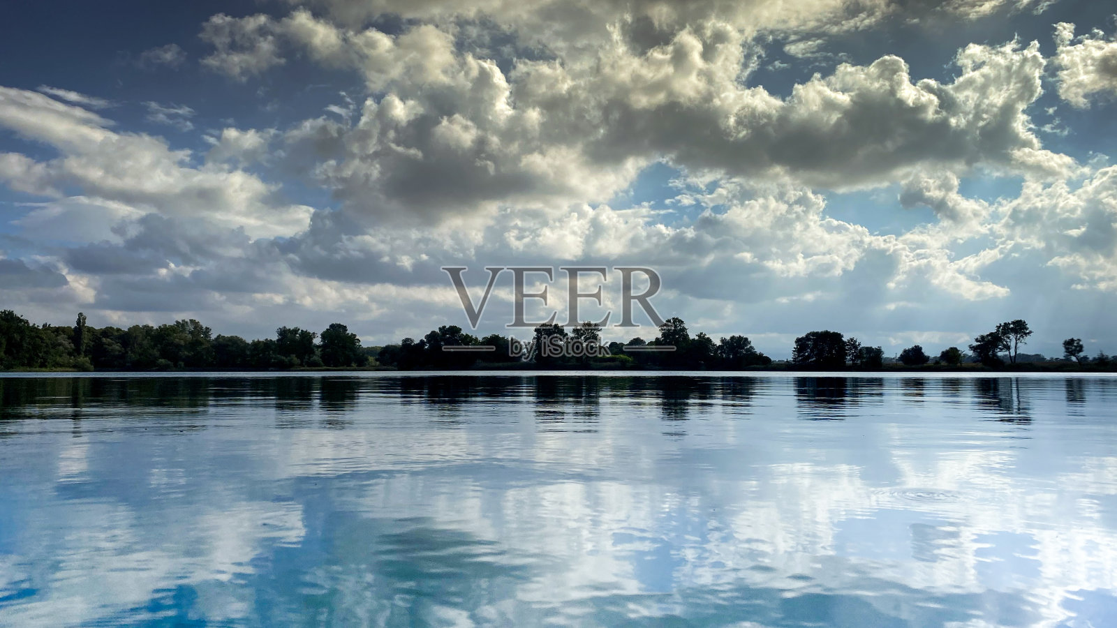 壮丽的景色在湖面与镜像云在天空和森林在海岸线照片摄影图片