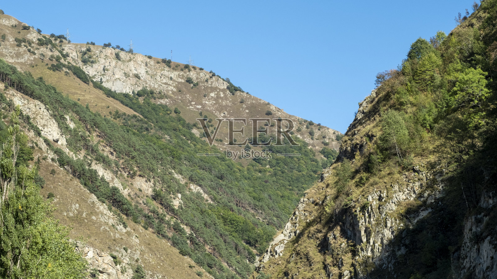 明亮阳光下的山景映衬着晴朗的天空照片摄影图片