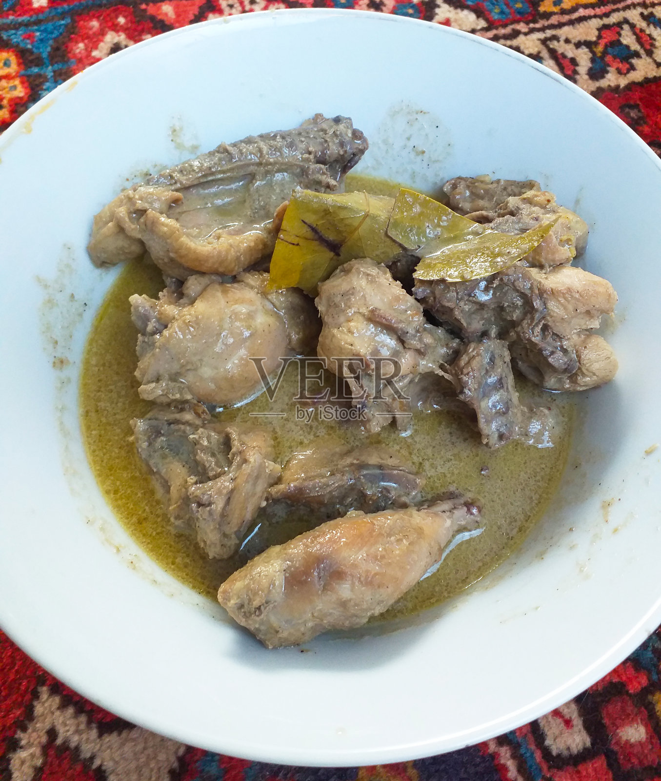 印尼西苏门答腊美食——自制的Opor Ayam或当地一种用椰奶制成的清淡鸡肉咖喱。照片摄影图片