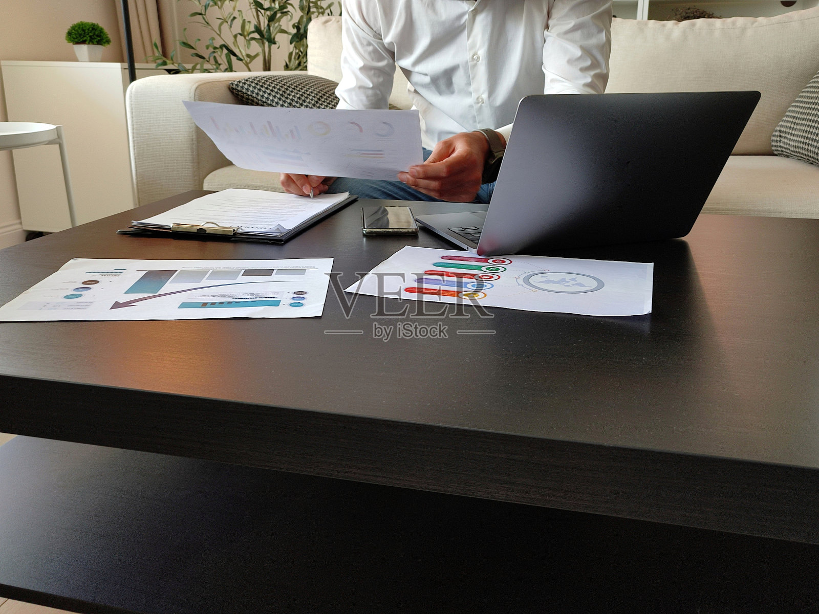 一个成熟的商人在办公室的桌子上阅读文件的镜头照片摄影图片