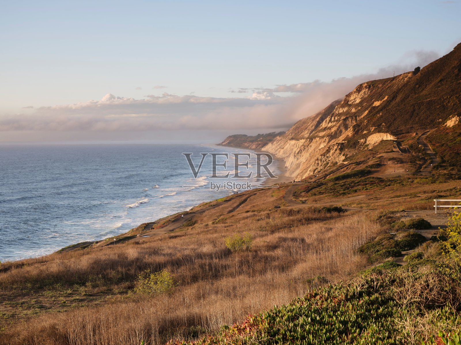 日落时的海岸悬崖和海浪照片摄影图片