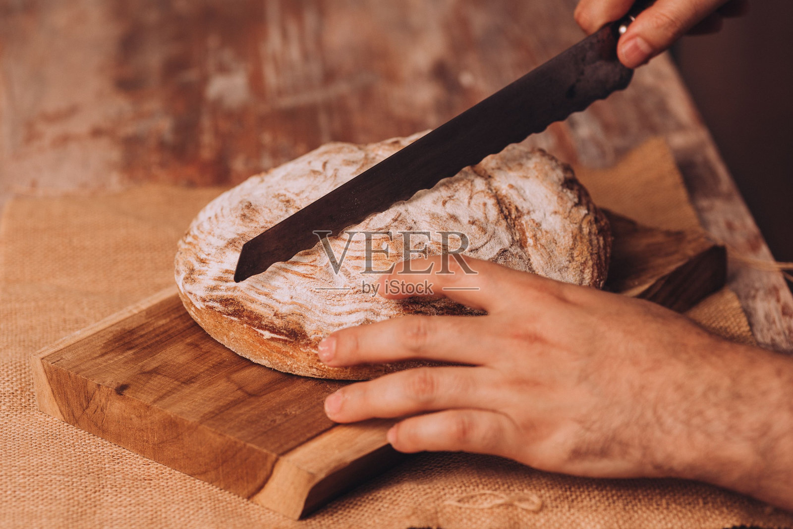 双手切着新鲜的面包照片摄影图片