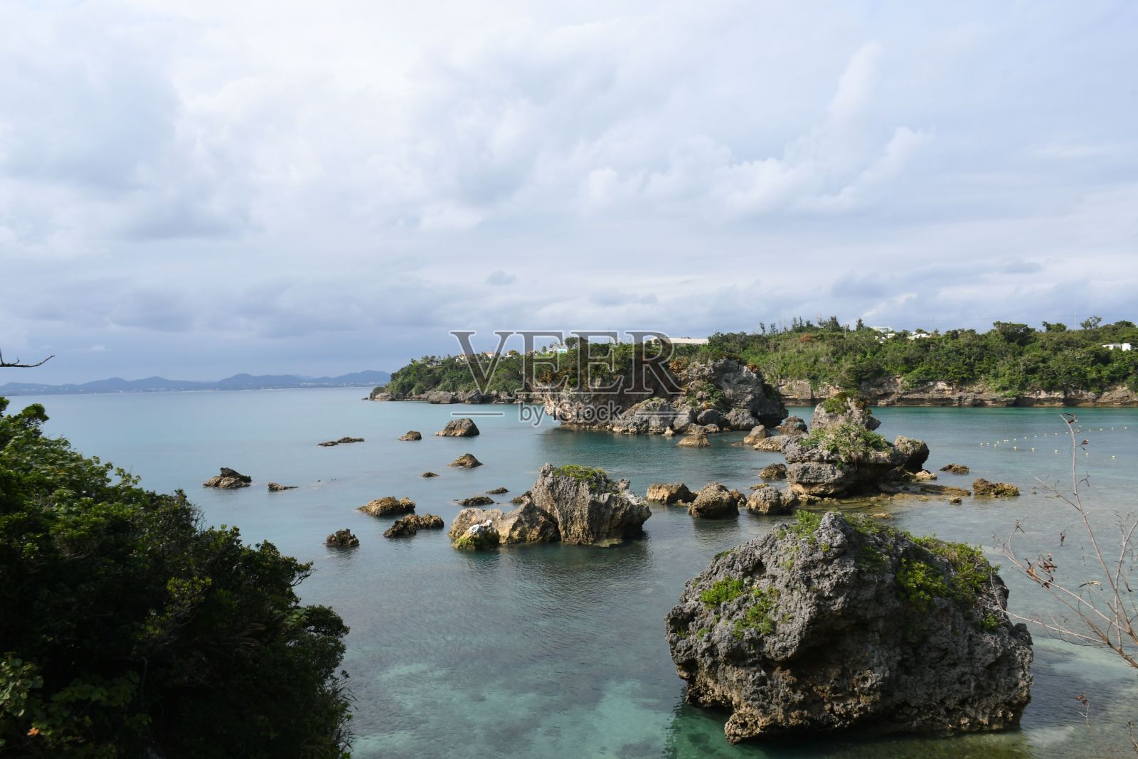 大海的景色与水中的大石头对着云雾密布的天空照片摄影图片