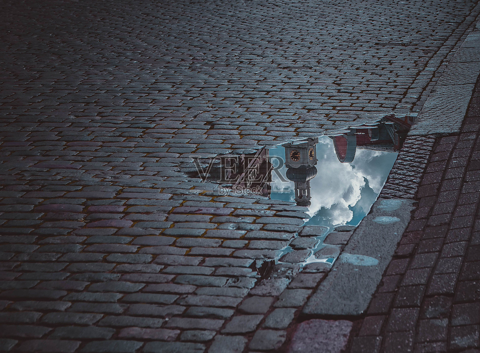 拉脱维亚里加,路面铺就的街道上的水坑,从高角度拍摄照片摄影图片