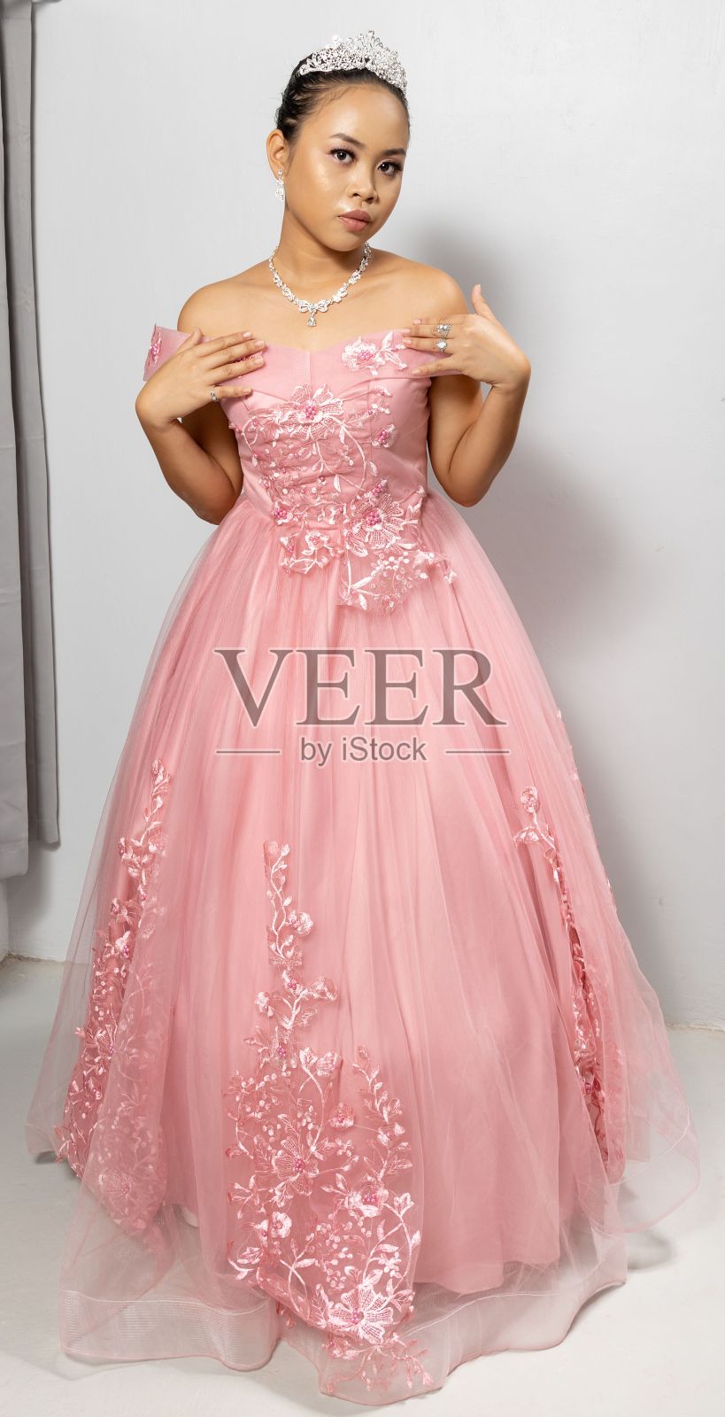 垂直拍摄一个美丽的菲律宾女孩在粉红色的公主服装和皇冠照片摄影图片