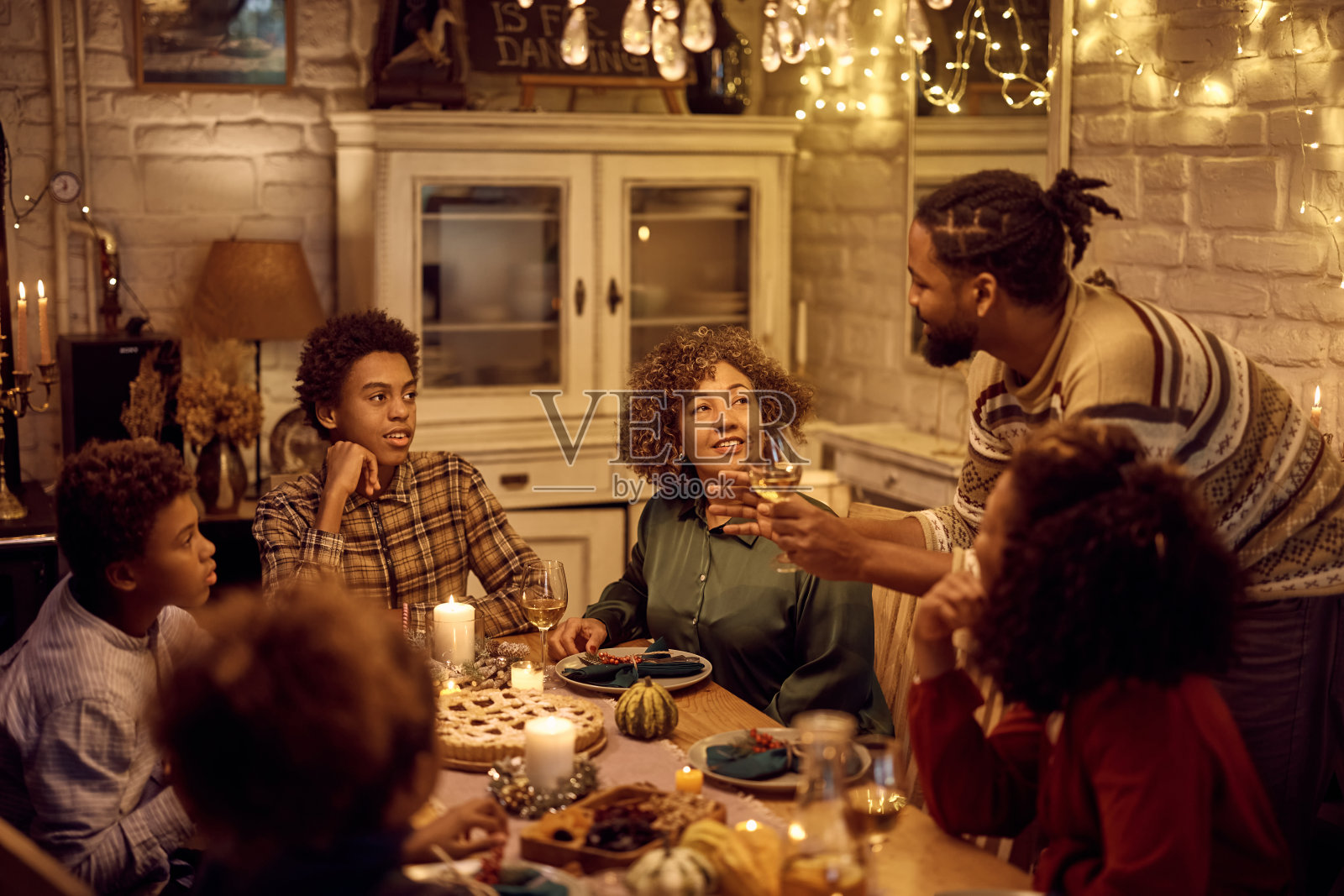 黑人多代人家庭在餐桌上交流感恩节晚餐。照片摄影图片