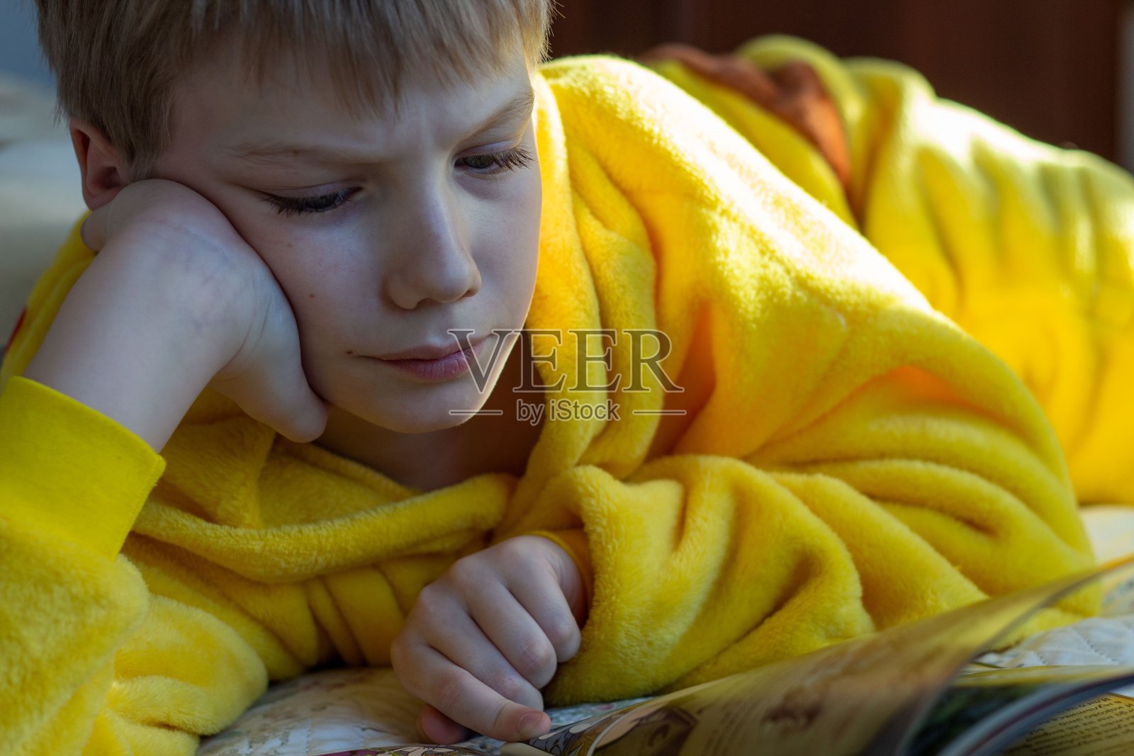 男孩躺在床上看书。儿童阅读家庭教育照片摄影图片