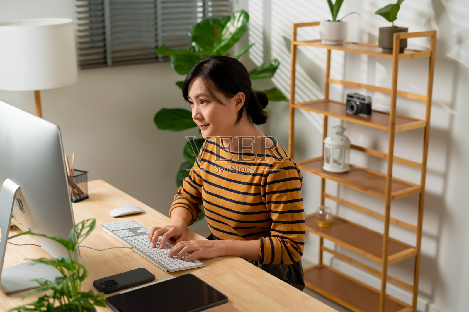 亚洲女性喜欢在家里办公时使用电脑。照片摄影图片