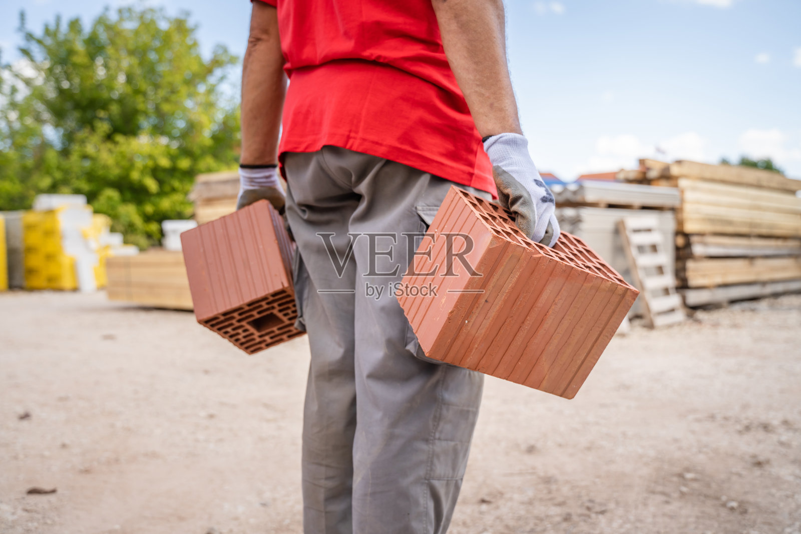 人们在建筑工地或仓库里拿着和搬运粘土块照片摄影图片