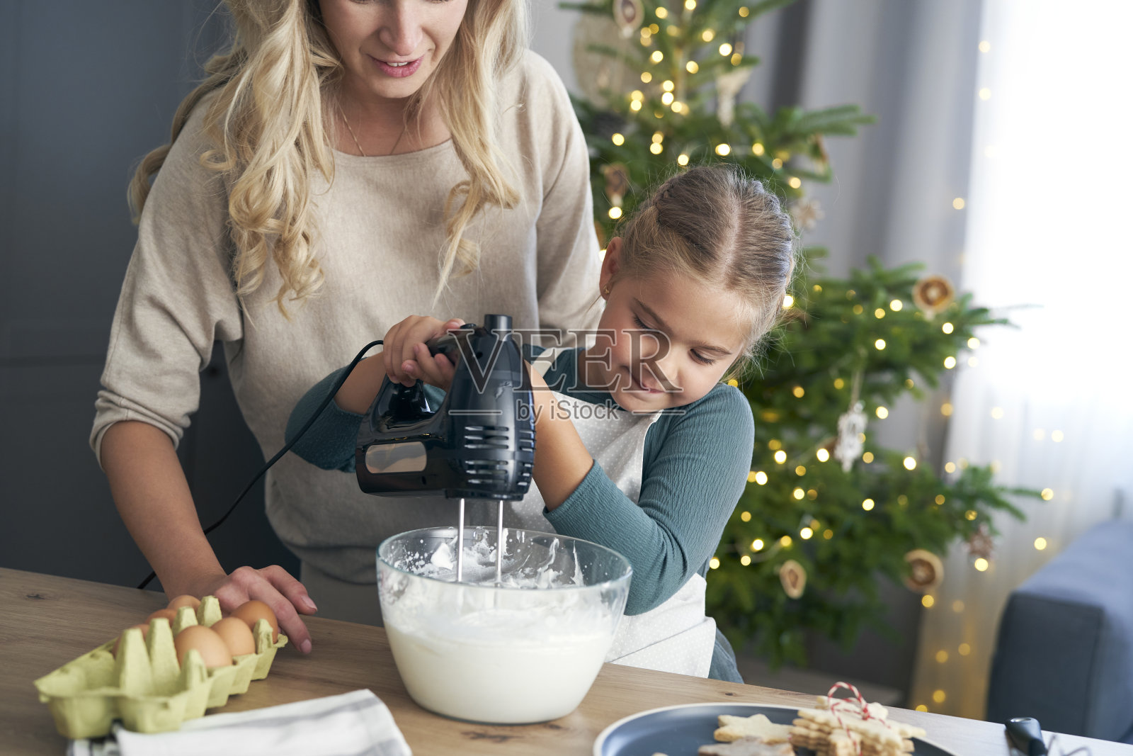 圣诞节前,白人母女在厨房里用电动搅拌机准备烘焙照片摄影图片