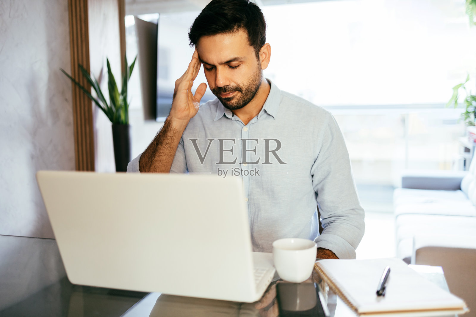 男子在家头痛,在笔记本电脑前照片摄影图片