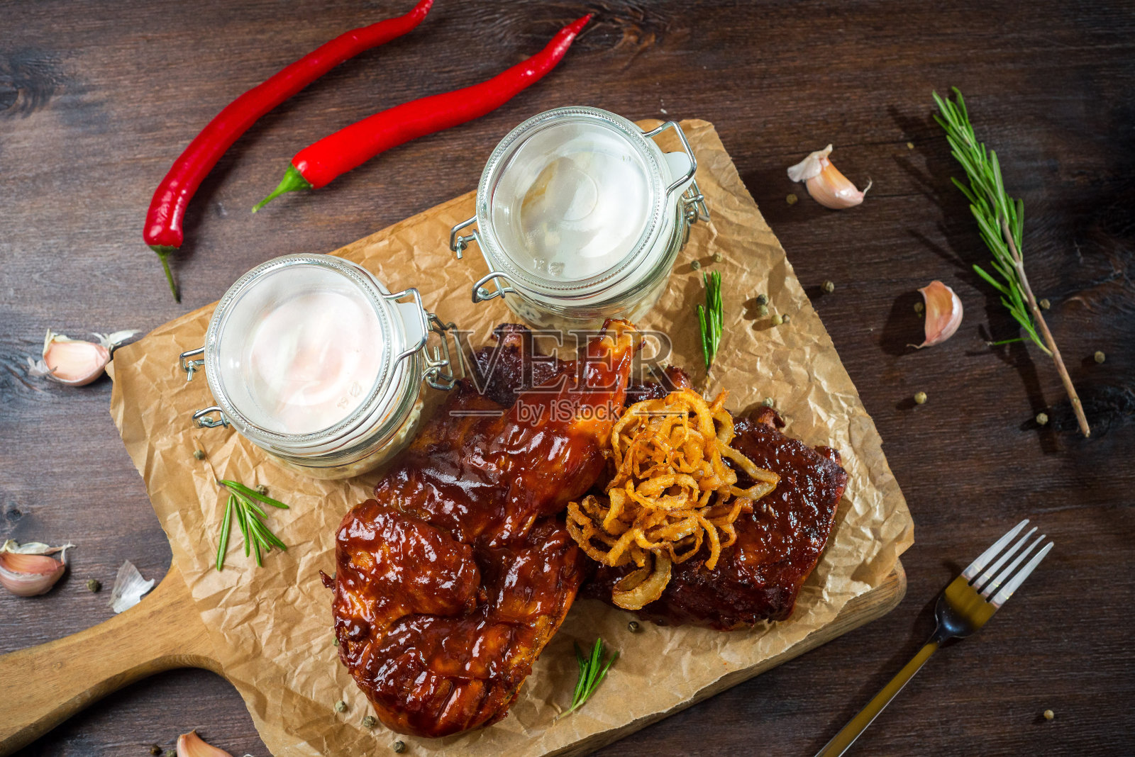 两份牛排配烧烤酱和炸洋葱,两罐凉拌卷心菜和苹果芹菜沙拉。两人份,装在木板上。照片摄影图片