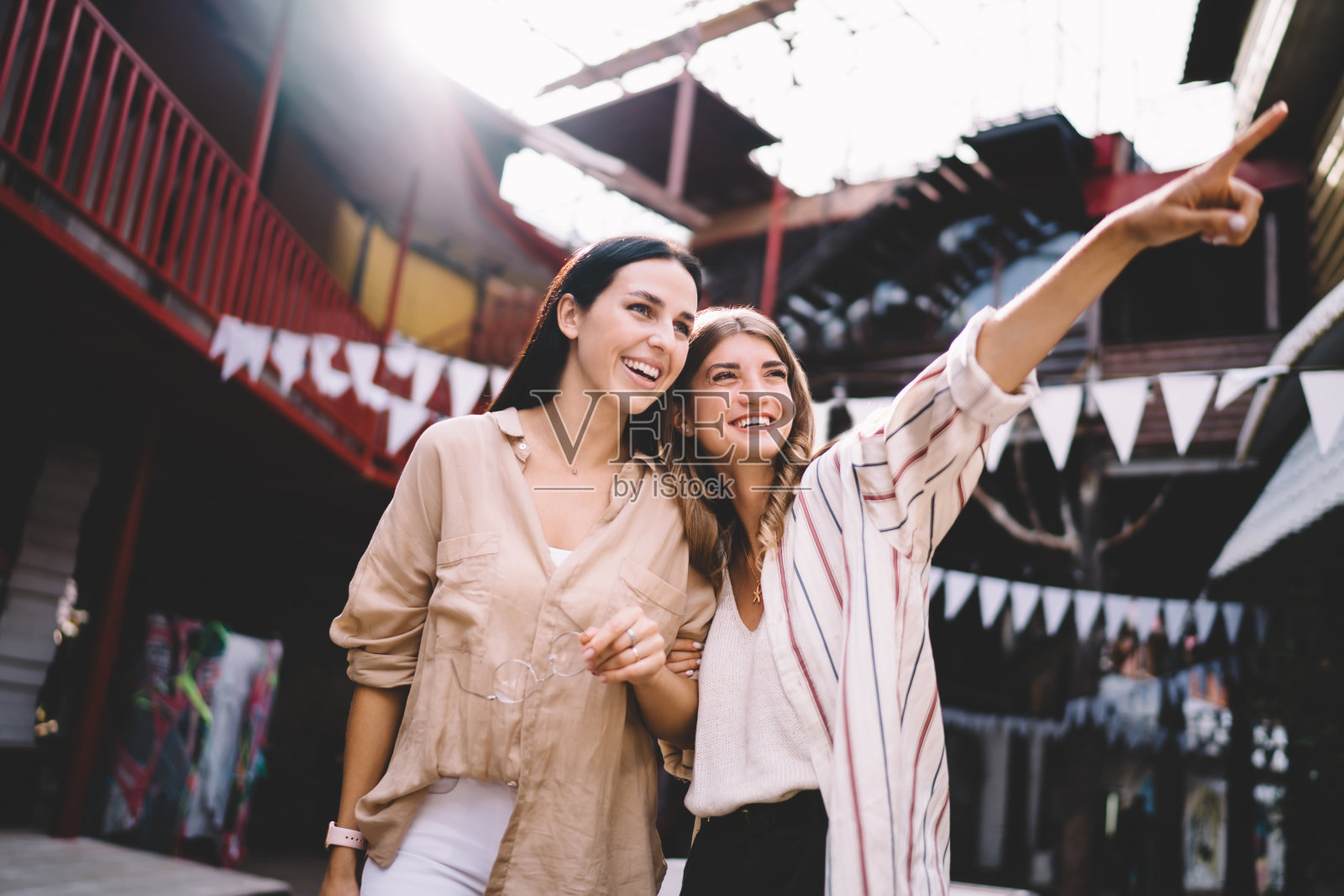 年轻的白人女性穿着时髦的衣服,一起享受假期,探索世界,在旅游观光期间讨论城市景观,快乐的朋友20岁在城市环境下社交照片摄影图片