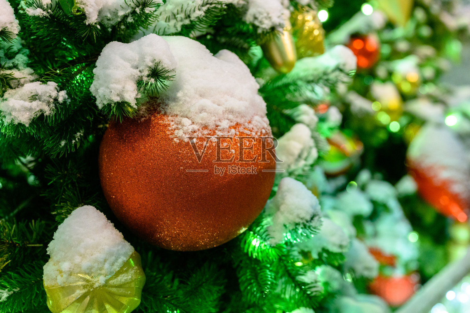 圣诞玩具在树上的雪。照片摄影图片