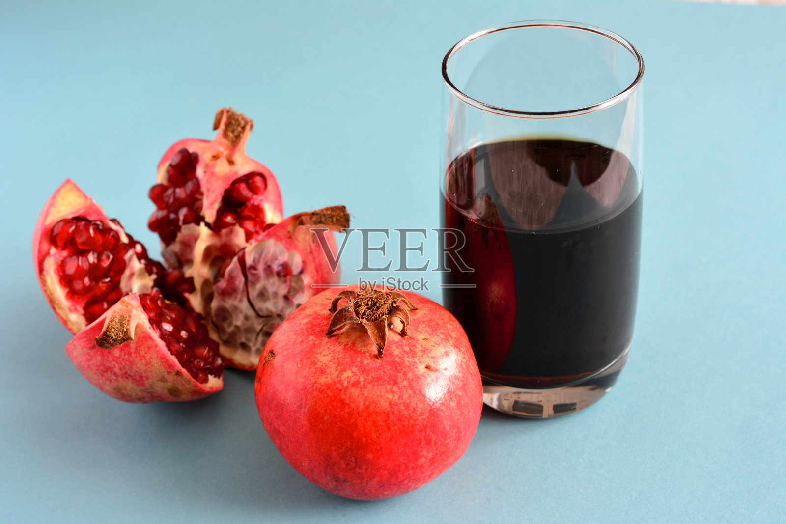 石榴果与一杯果汁隔离,特写照片摄影图片