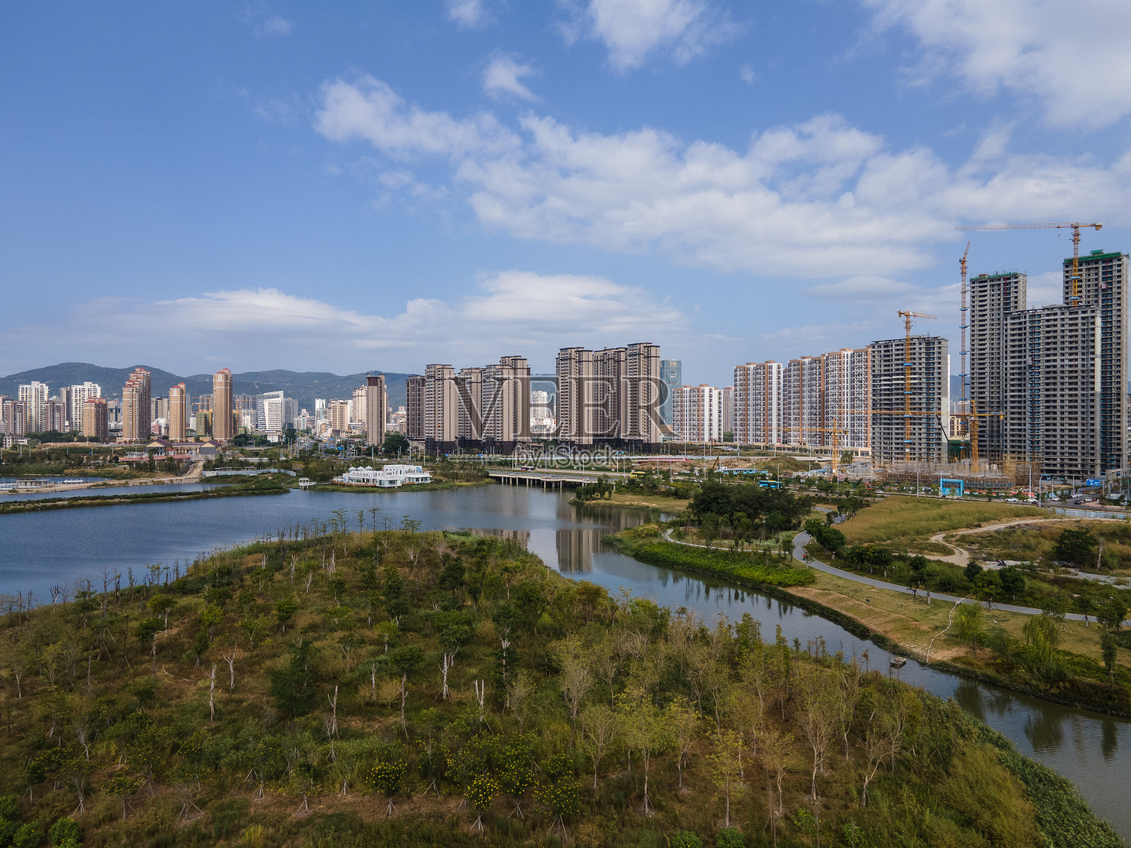 湖边的城市和在建的高楼大厦照片摄影图片