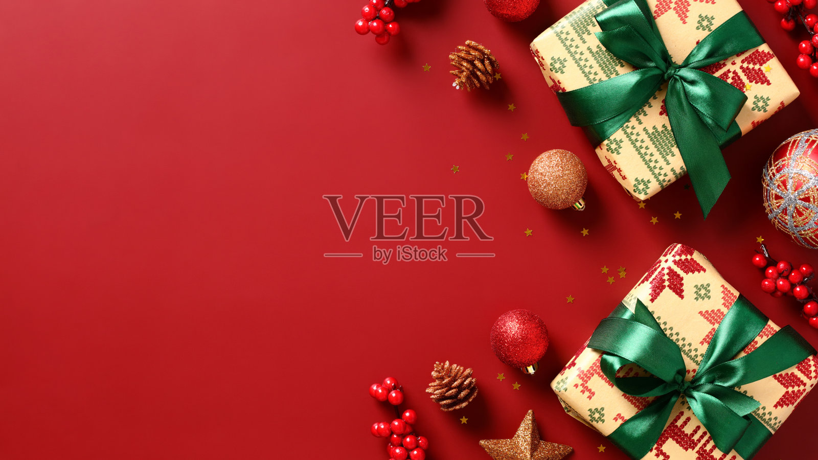 圣诞节旗帜设计。复古礼盒与绿色丝带,小玩意,红色背景的红色浆果树枝。圣诞贺卡,新年头模板。照片摄影图片