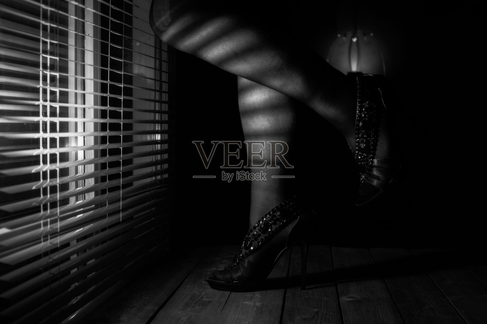 优雅的高跟鞋的灰度特写,木制背景附近的百叶窗,光从照片摄影图片