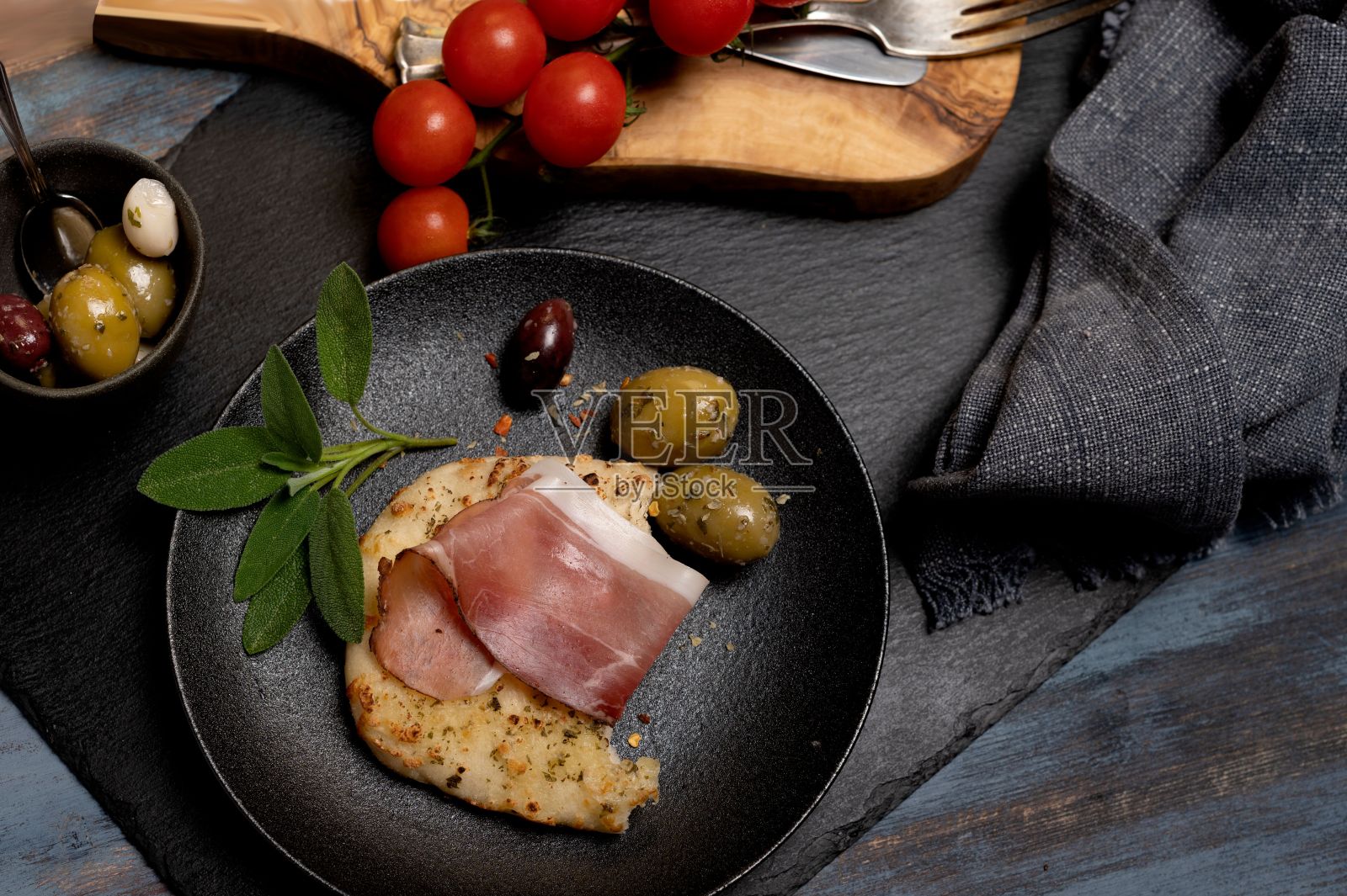 一片佛卡夏面包配火腿橄榄和香草照片摄影图片