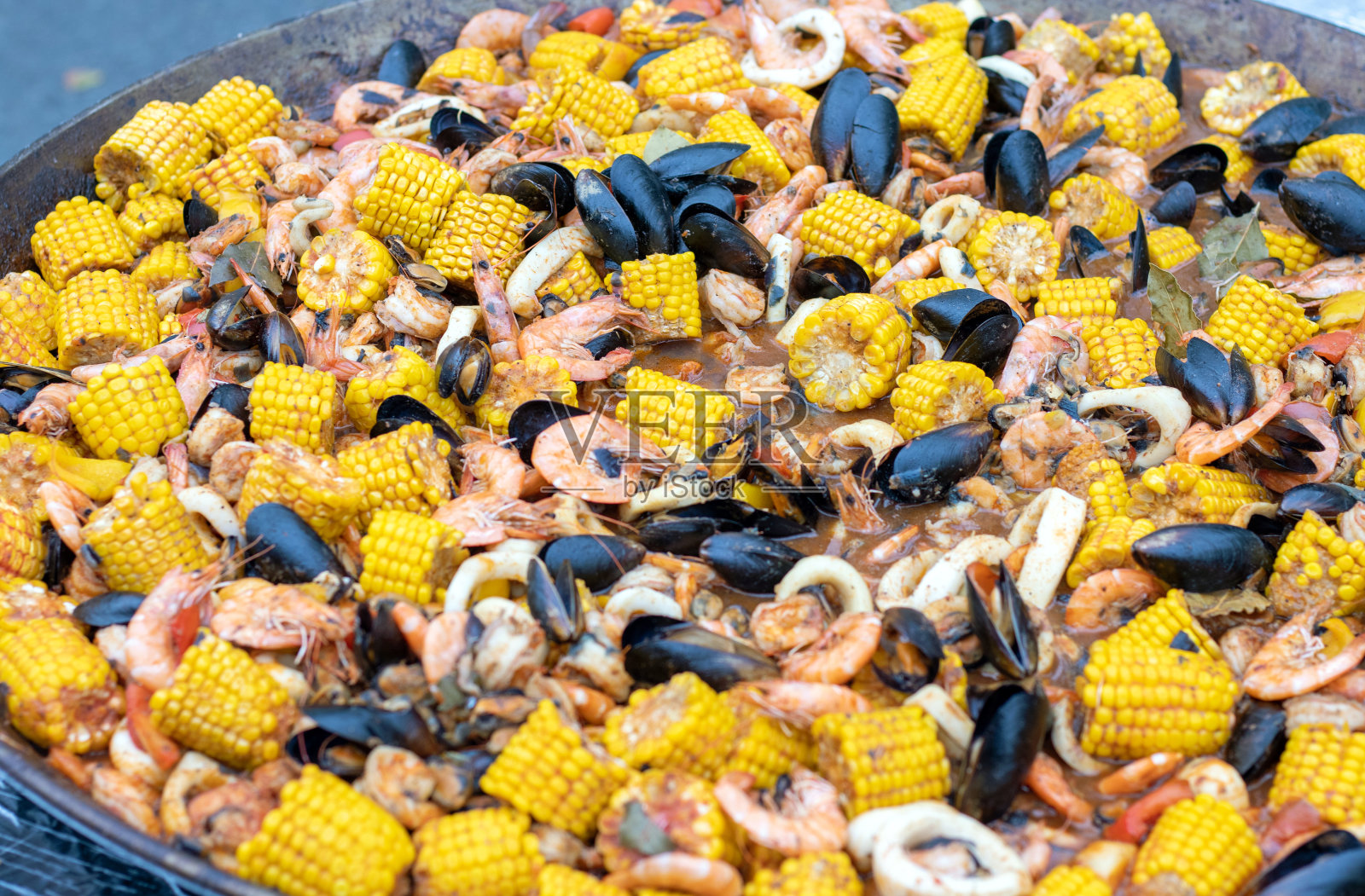 街头美食城市日。烧烤猪肉鸡肉,甜玉米蔬菜土豆海鲜虾和贻贝。男人做饭照片摄影图片