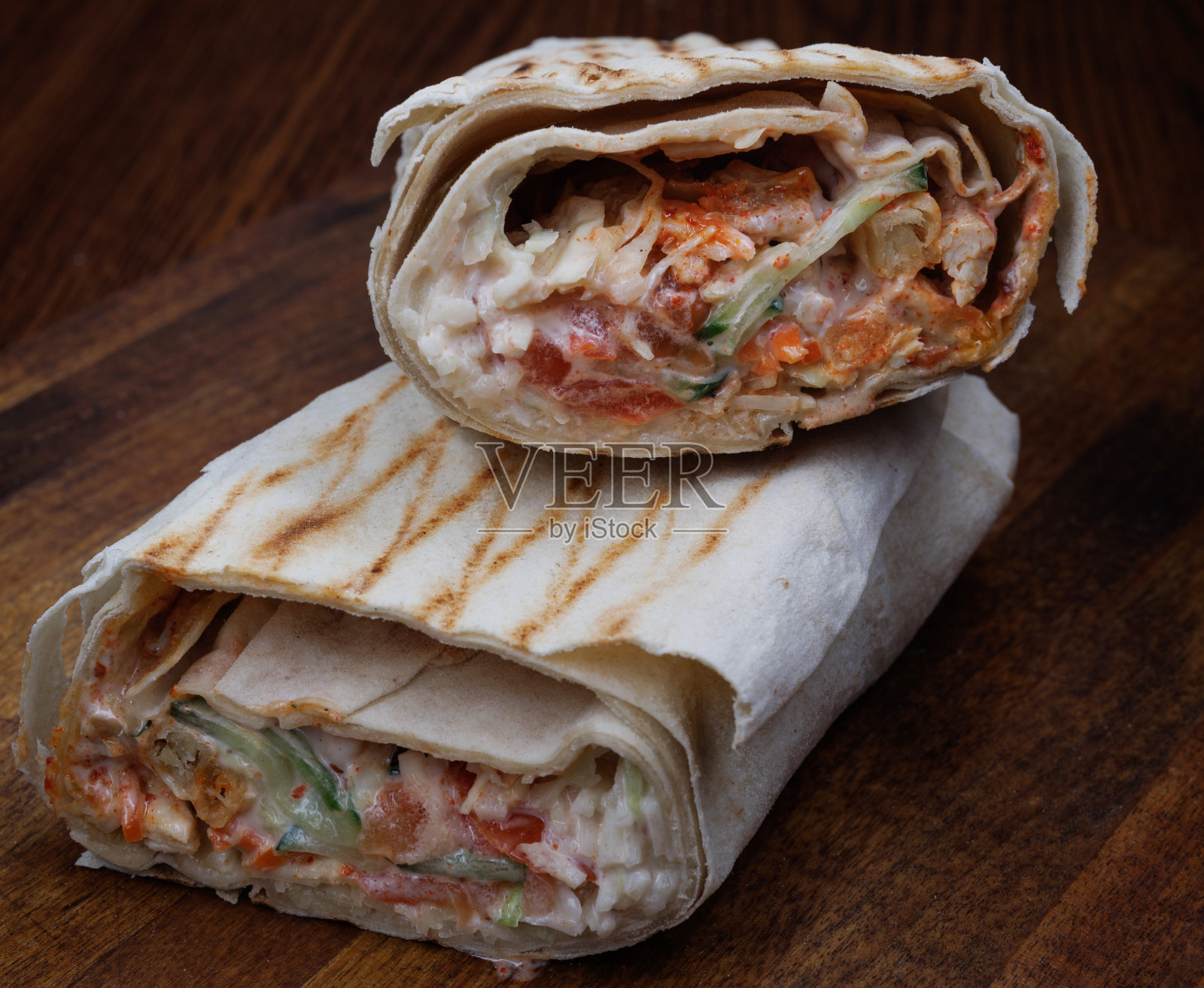 切好的沙瓦玛放在一张木桌上。照片摄影图片