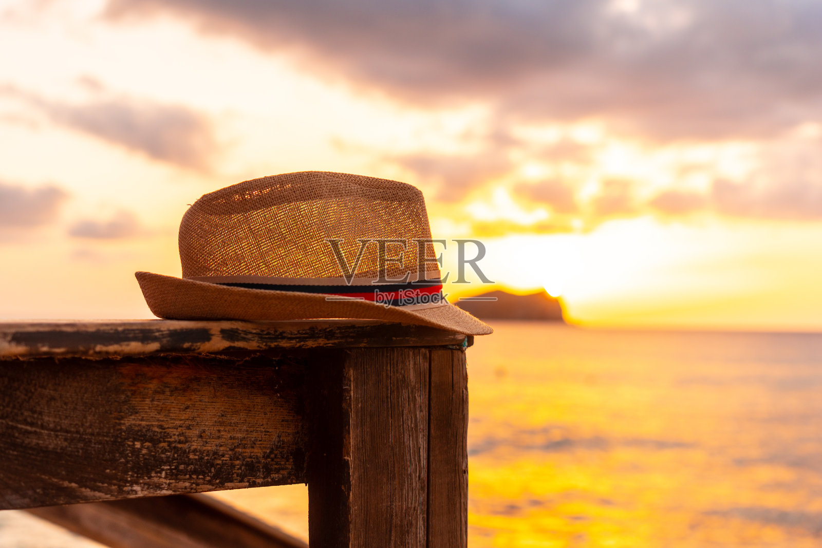 在伊比沙岛的卡拉康特海滩,游客在日落时戴上帽子。巴利阿里群岛,度假的概念照片摄影图片