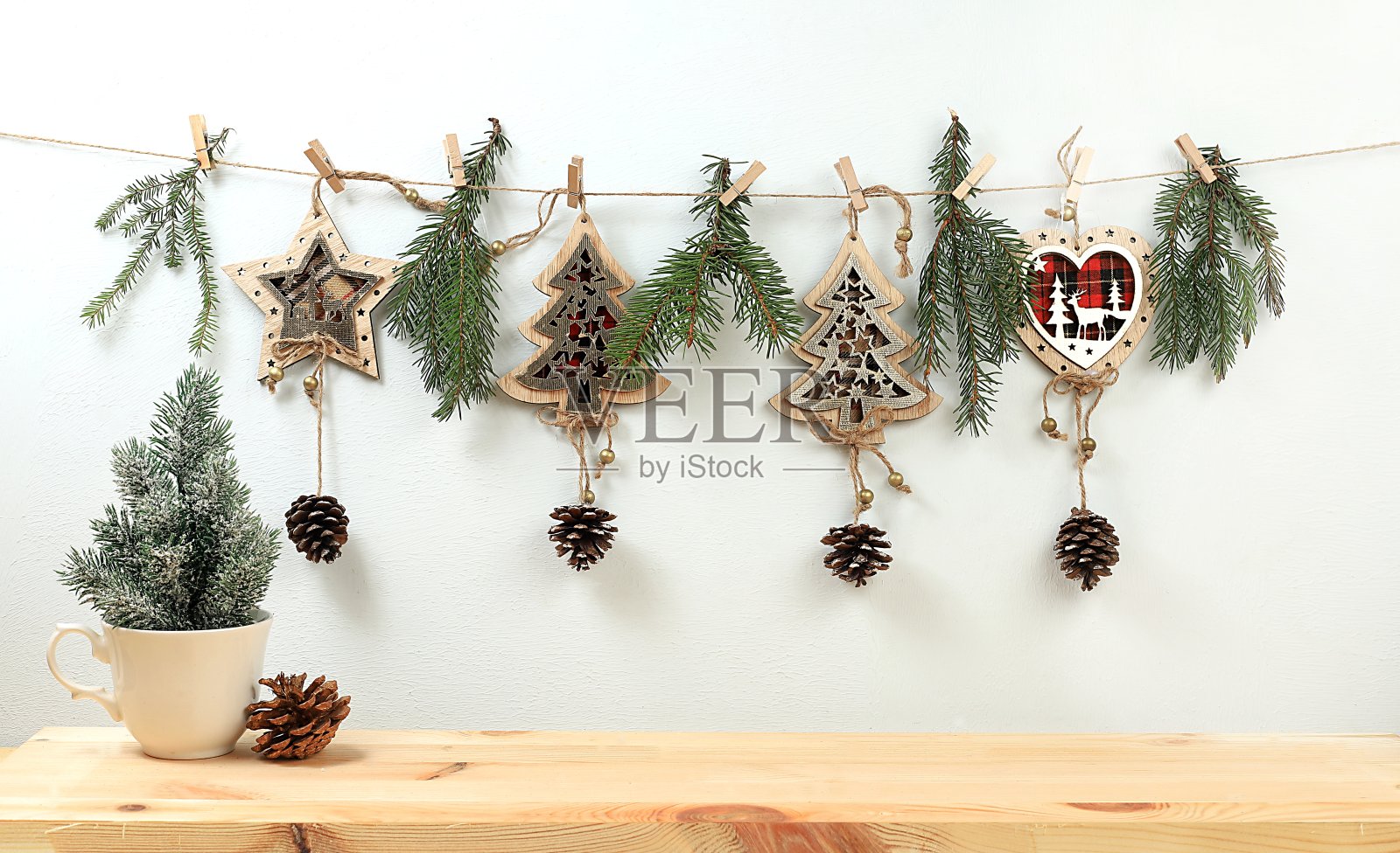 空的乡村桌子,马克杯里有一棵活的圣诞树,松果,肉桂和自制的木制装饰品。照片摄影图片