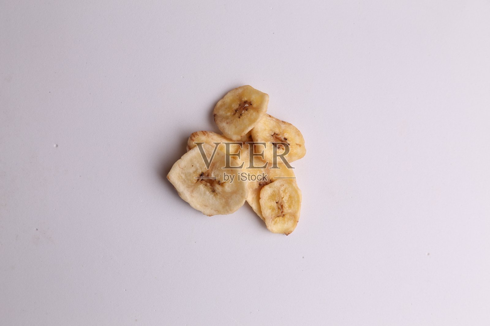 头顶上,灰色的桌子上美味地摆放着营养丰富的干香蕉片照片摄影图片