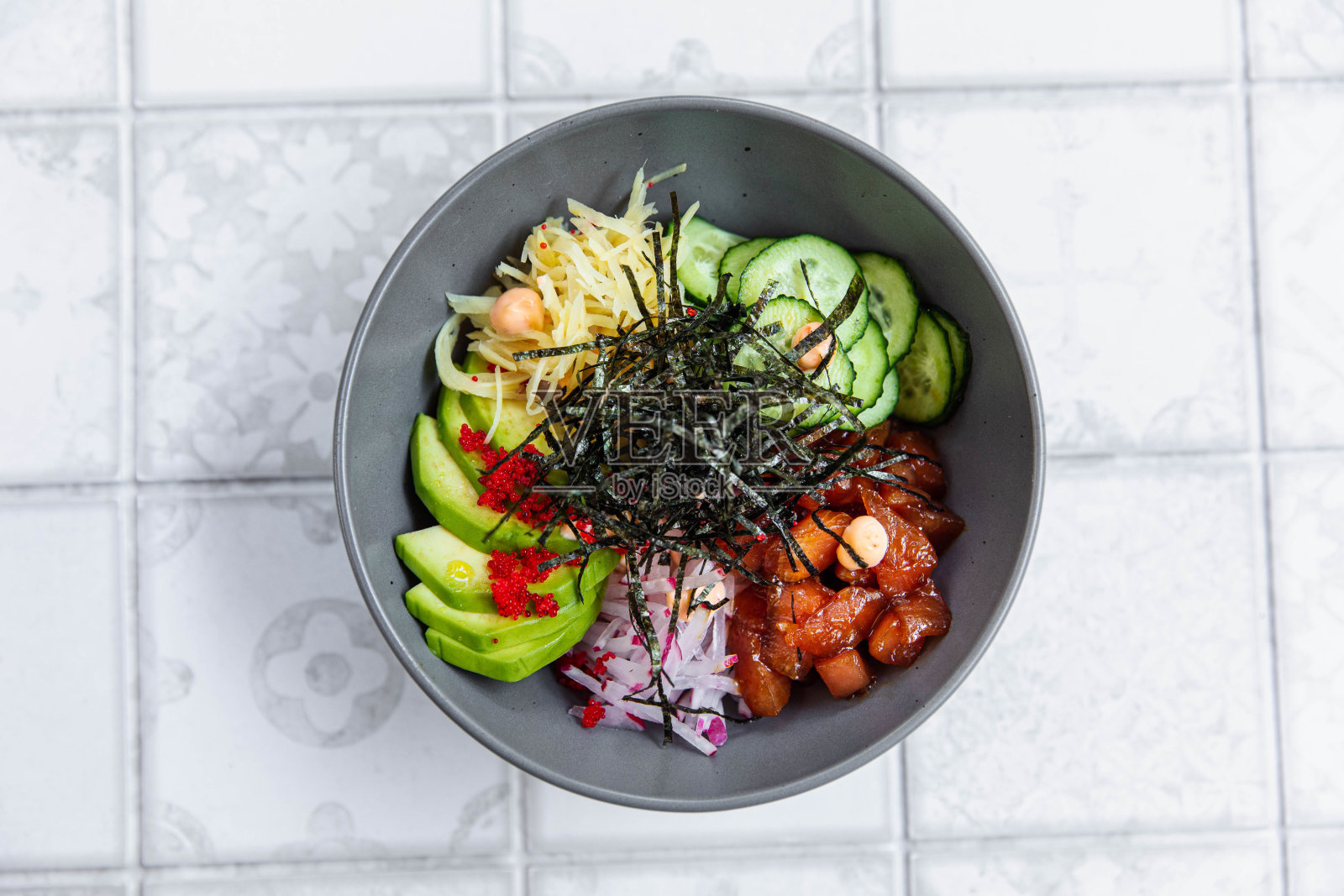 黑色碗和水果沙拉,把奶油倒在水果沙拉和白色背景上照片摄影图片