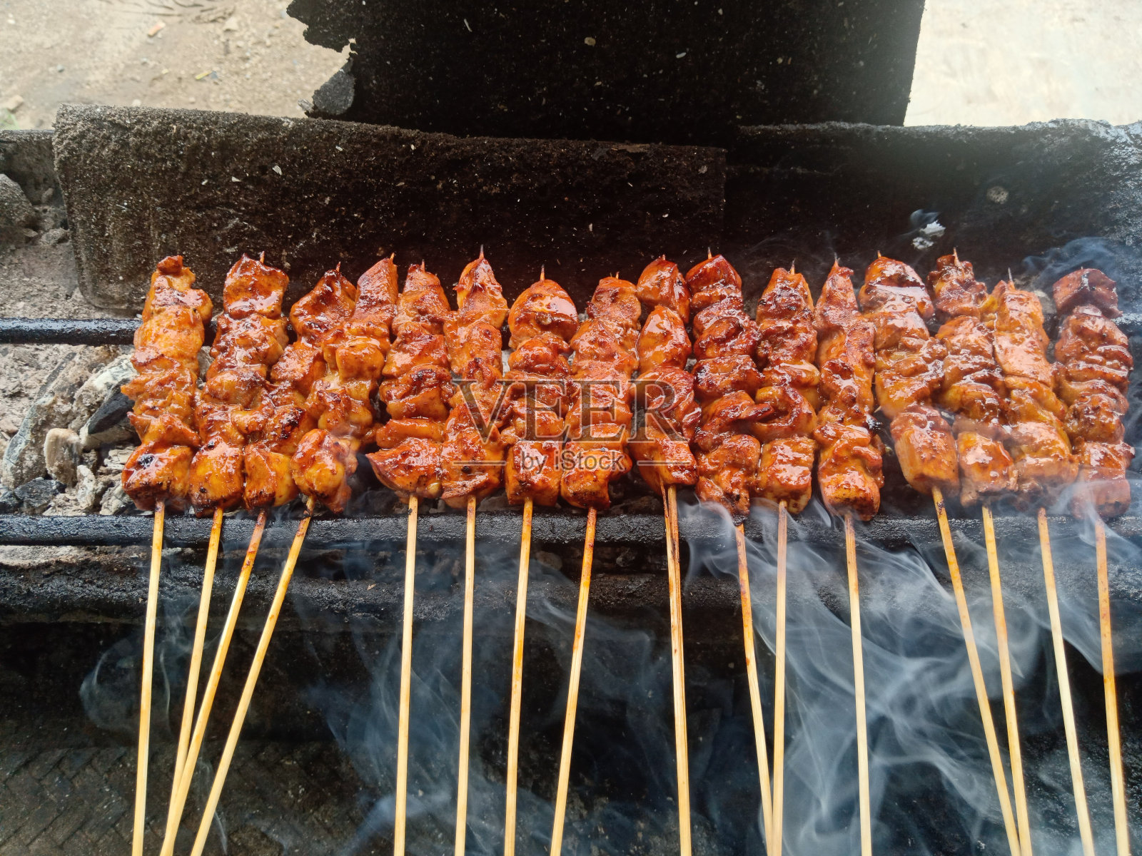 在木炭上烧烤的沙爹鸡会冒烟照片摄影图片