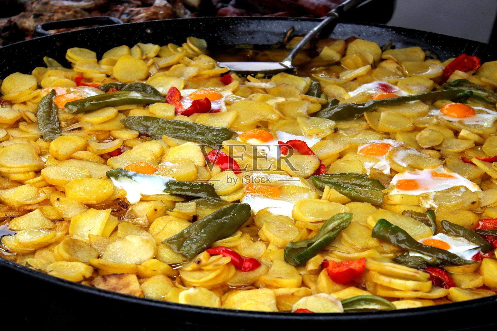 混合了美味的煎蛋、红青椒和典型西班牙风格的烤土豆。照片摄影图片