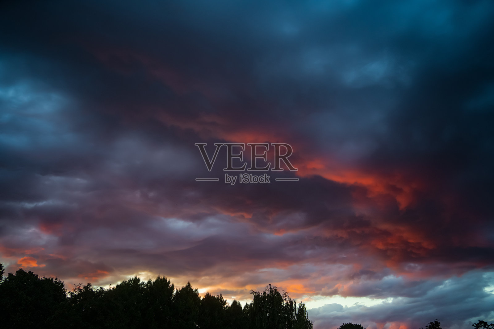 在美丽的红色日落时,天空中戏剧性的云。自然环境背景照片摄影图片