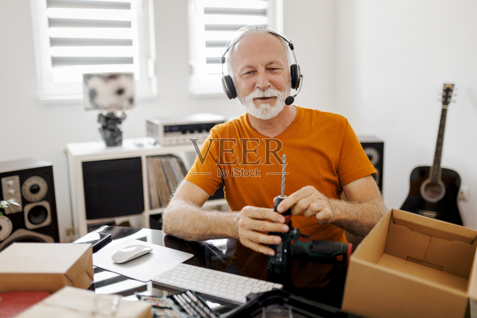 微笑的男性社交媒体技术影响者在家里录制开箱视频照片摄影图片